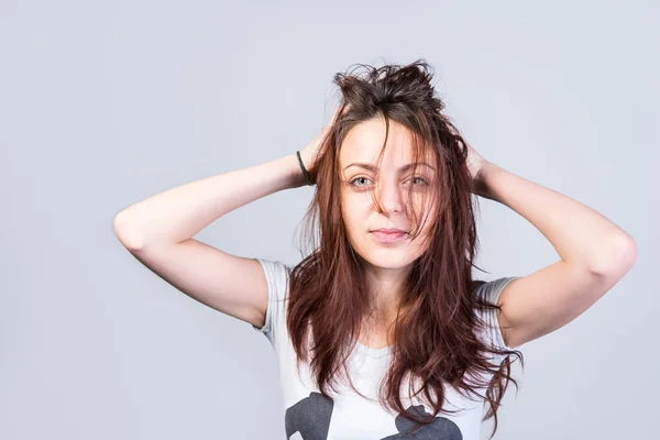 Mujer sosteniendo desordenado cabello mirando a la cámara —  Fotos de Stock