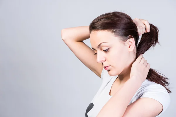 Young woman tying up her hair — Stock Photo, Image