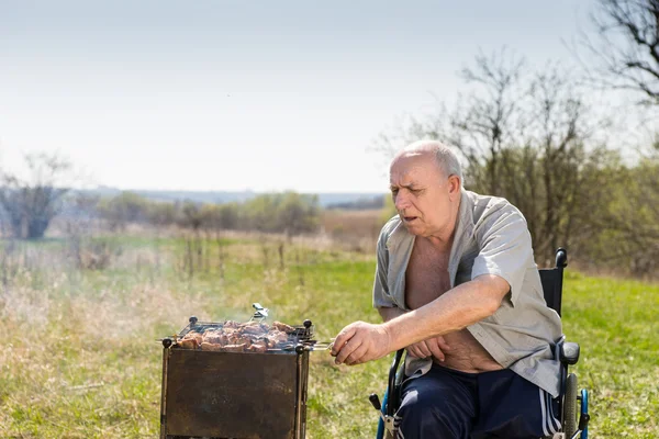 Funktionshindrade äldre Man grilla i parken ensam — Stockfoto