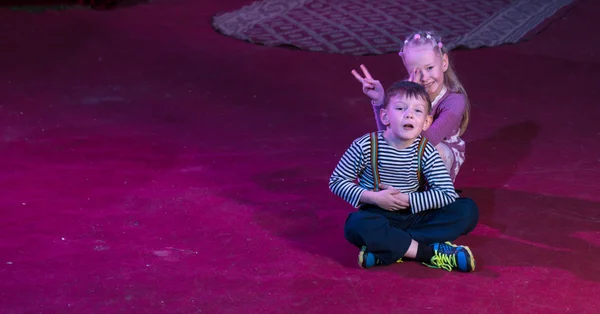 Jongen en meisje zitten samen op het podium — Stockfoto