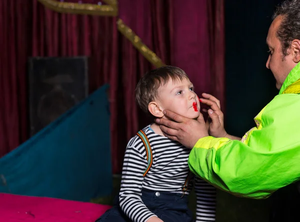 Hombre aplicando payaso cara maquillaje en chico — Foto de Stock