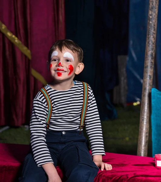 Lycklig pojke med clown utgör sitter på en scen — Stockfoto