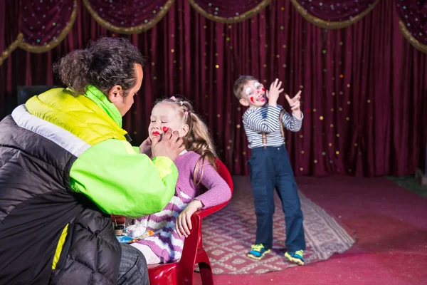 Hombre aplicando maquillaje a cara de chica en el escenario — Foto de Stock
