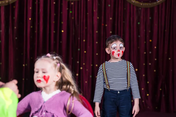 Chico payaso y chica teniendo maquillaje aplicado en el escenario — Foto de Stock