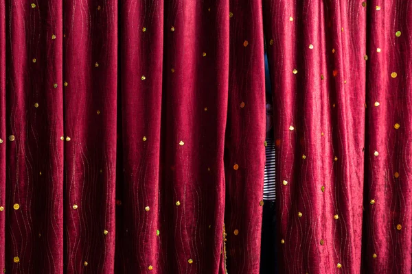 Little boy lurking behind the stage curtains