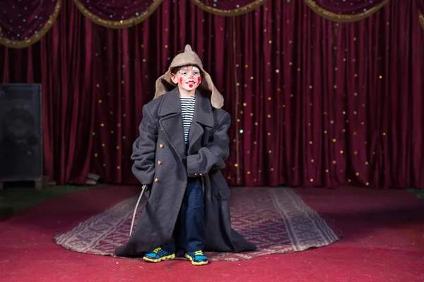 Boy wearing retro coat and Russian hat on stage — Stock Photo, Image