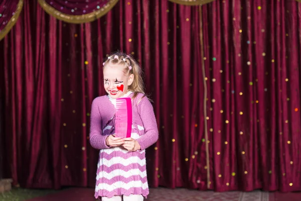 Flicka klädd Clown utgör innehar stor kam — Stockfoto