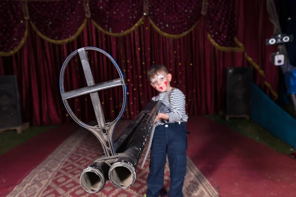 Junge Clown mit großer Waffe auf der Bühne — Stockfoto