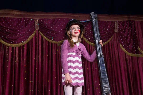 Girl Wearing Helmet Holding Gun Upright on Stage — Stock Photo, Image