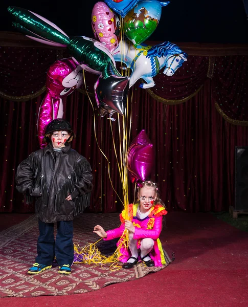 Хлопчик клоун на сцені з дівчинка тримає повітряні кульки — стокове фото