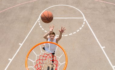 Genç adam alarak kadar atış basketbol sahası üzerinde yatıyordu