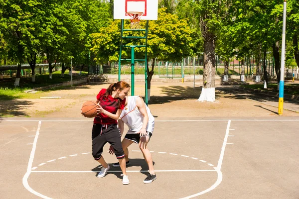 Casal jogando basquete na quadra ao ar livre — Fotografia de Stock