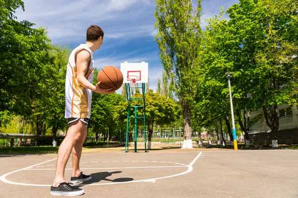 Atletische Man gratis gooien basketbal richting hoepel — Stockfoto