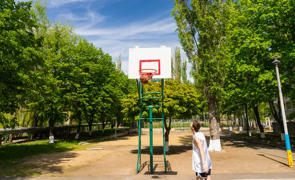 Hombre haciendo tiro en la red en la cancha de baloncesto — Foto de Stock