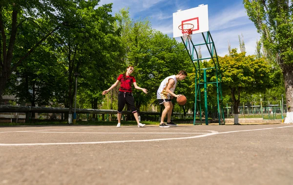 Pár hraje basketbal na venkovním hřišti — Stock fotografie