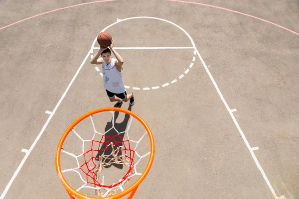 Jovem tomando tiro na Net na quadra de basquete — Fotografia de Stock