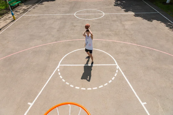 Homem tomando tiro na rede na quadra de basquete ao ar livre — Fotografia de Stock