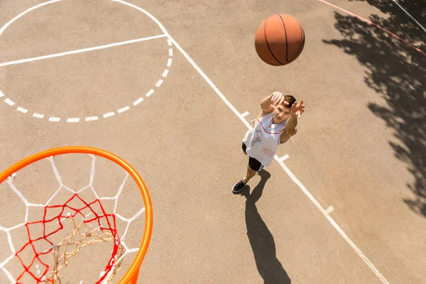 Vista superior del hombre lanzando baloncesto en el aro — Foto de Stock