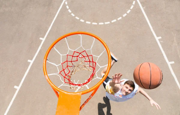 Giovane uomo rendendo laici girato su basket rete — Foto Stock