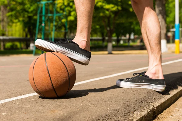 Primer plano del hombre con pie en el baloncesto en la cancha —  Fotos de Stock