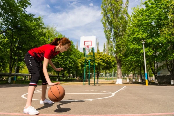 Kobieta lekkoatletycznego dryblingu koszykówkę w połowie sąd — Zdjęcie stockowe