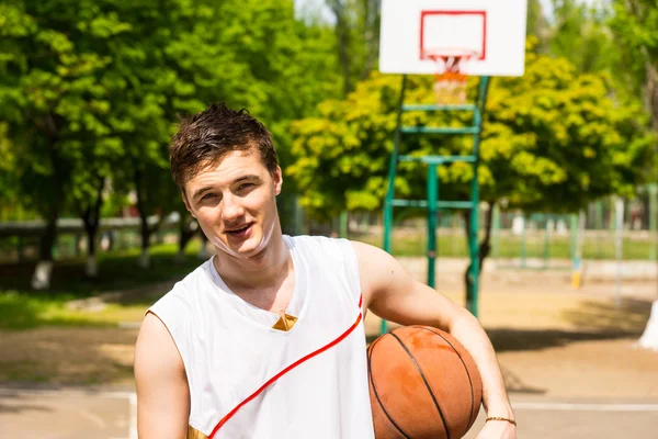 Lekkoatletycznego mężczyzna na boisko trzymając piłkę — Zdjęcie stockowe