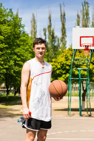 Muž stojící na košíkovou, držení míče — Stock fotografie