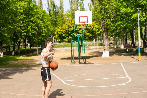 Giovane uomo che gioca a basket da solo sul campo — Foto Stock