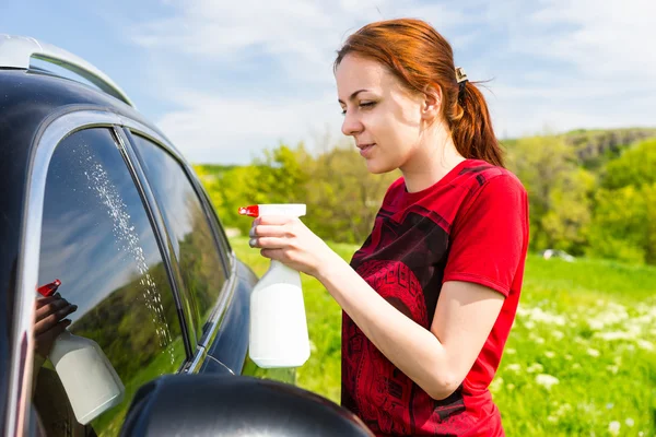 Ventanas de coche de limpieza de mujer con limpiador de aerosol —  Fotos de Stock