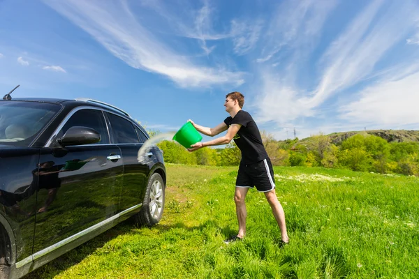 Man zwarte auto wassen in groene veld — Stockfoto