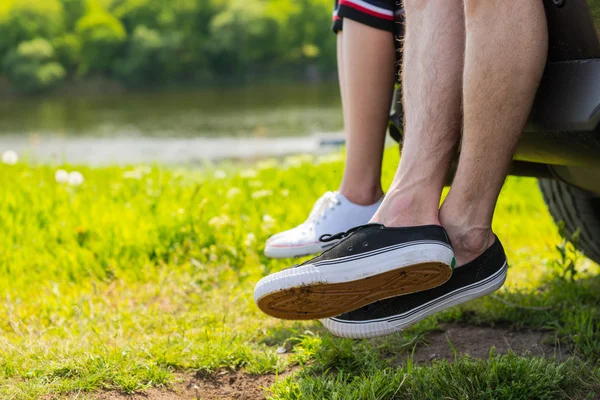 Couple Wearing Sneakers Sitting on Tailgate of Car — Stock Photo, Image