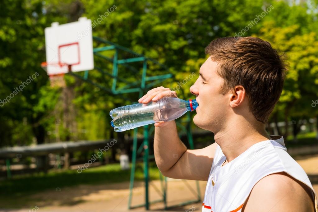 young man or teenager drinking water from bottle Stock Photo