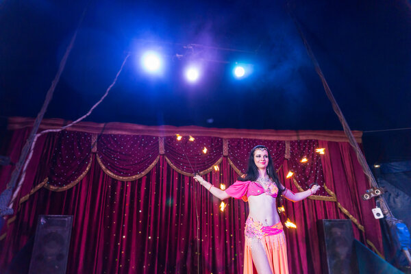 Танцор-пожарный танцует зажигательные дубинки на сцене
