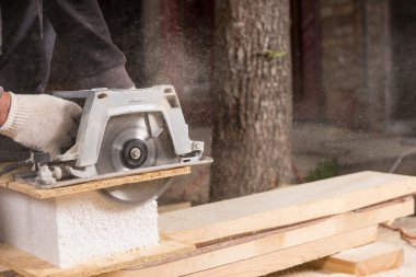 Ahşap plakalar kesmek için güç kullanan adam gördüm