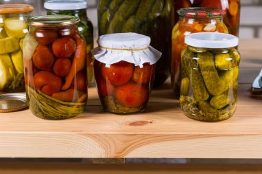 Ahşap masada kavanozlar dolusu sebze turşusu.