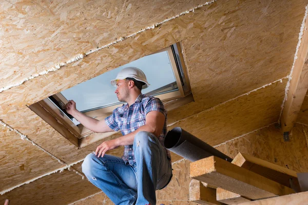 Constructor inspeccionando tragaluz en casa inacabada — Foto de Stock