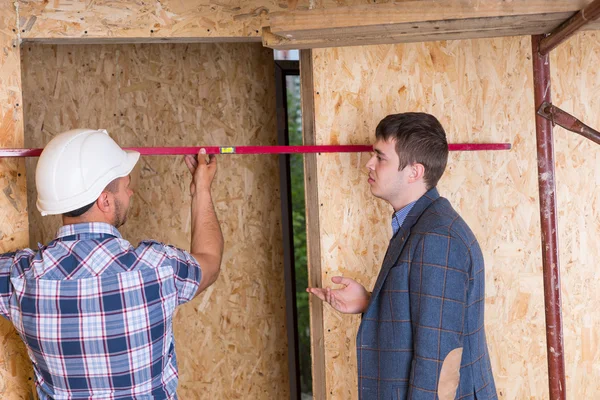 Construtor e arquiteto que inspeciona a moldura da porta — Fotografia de Stock