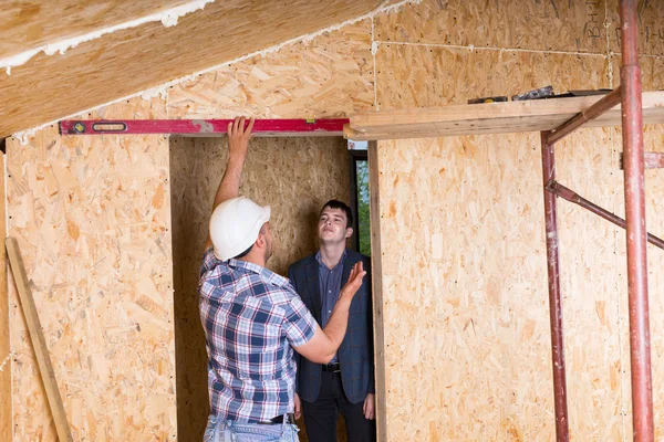 Construtor e arquiteto que inspeciona a moldura da porta — Fotografia de Stock