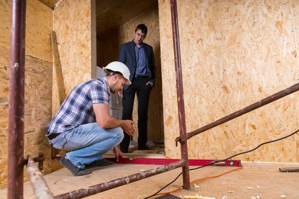 Nivel del marco de la puerta de control del trabajador en un nuevo hogar — Foto de Stock