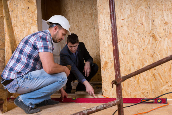 Builder and Architect Inspecting Building Doorway