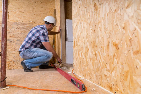 Marco de la puerta de medición del constructor en la casa sin terminar — Foto de Stock