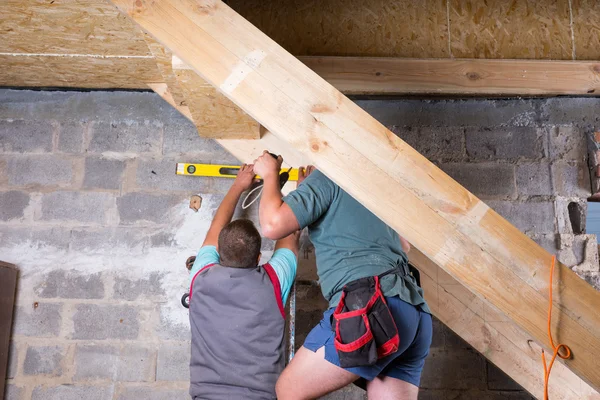 Dois homens construindo escadas no porão inacabado — Fotografia de Stock