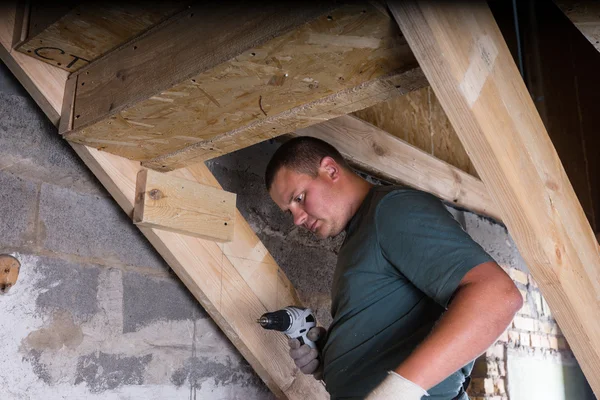 Bauarbeiter mit Bohrmaschine baut Treppe im Keller — Stockfoto