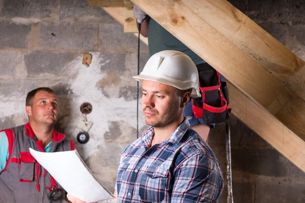 Foreman met plannen toezichtactiviteiten op trap — Stockfoto