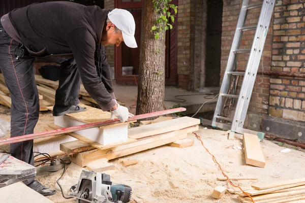 Man met behulp van kracht zag te snijden planken van hout — Stockfoto