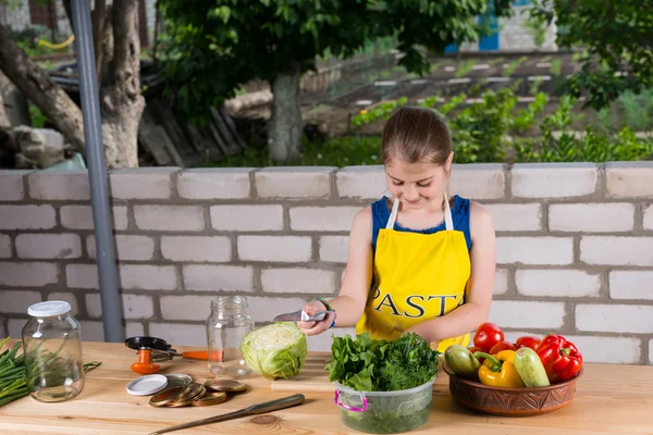 Ung flicka förbereda färska grönsaker utomhus — Stockfoto