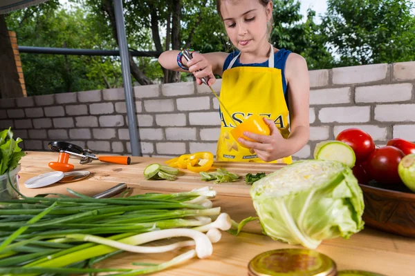 Jong meisje reinigen een paprika — Stockfoto