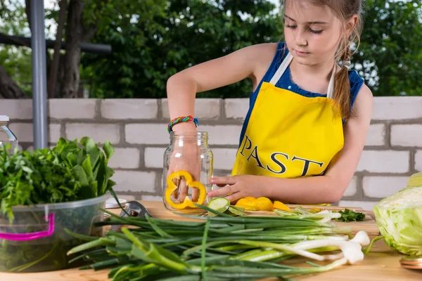 Menina jovem cortando legumes frescos para enlatamento — Fotografia de Stock