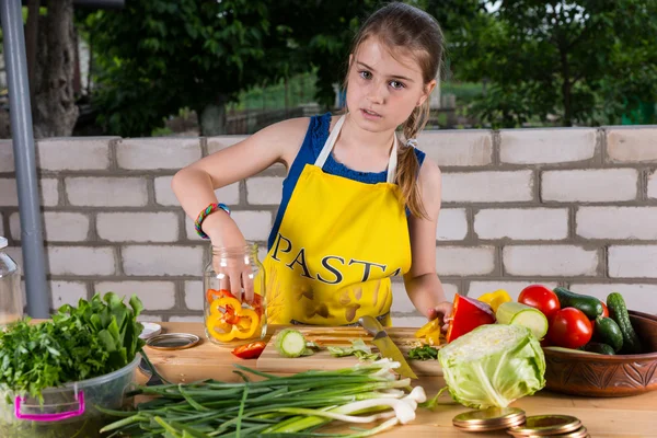 Giovane ragazza imbottigliamento colorati peperoni — Foto Stock