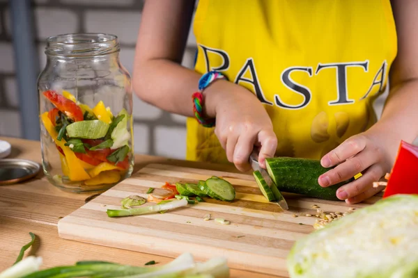 Menina jovem cortando pepino endro para engarrafamento — Fotografia de Stock